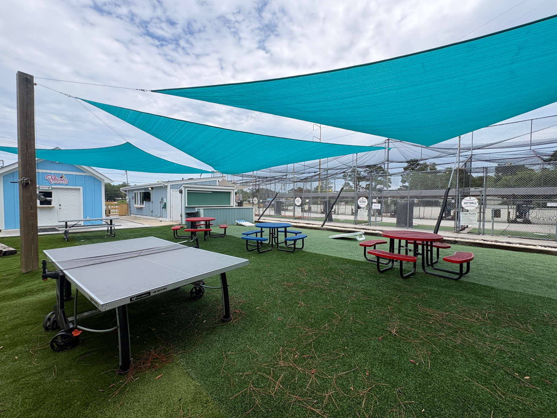 Turf beer garden at Bats and Brews with shade sails, picnic tables and yard games